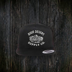 Mountains Logo Flat Brim Black front - dark wood style, hat framing rescaled to match other colorways (reverted from logo-shrink edit chain, no clean blend achieved)
